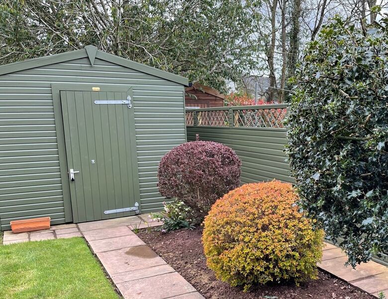 Garden shed with matching green fencing image #1