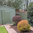 Garden shed with matching green fencing image #1