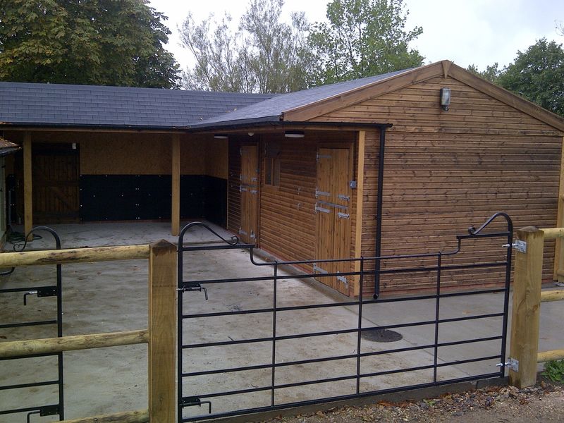 Stables with shoeing/washdown area with shingle roof image #1